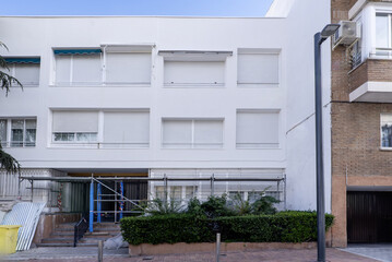 White facade of a residential building undergoing renovation