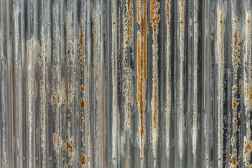 A corrugated metal background with many rust stains