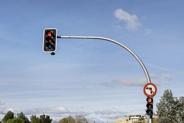 A curved pole holding a red traffic light