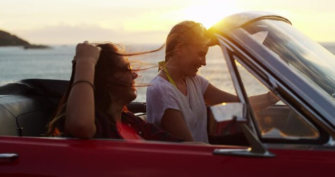 Women on road trip with car, ocean and laughing with freedom, nature and bonding at sunset vacation. Happy travel friends in convertible, adventure and journey at beach on excited drive on holiday.