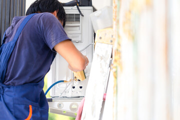 Technicians man check leak of air conditioners systems , Air conditioning technicians install new air conditioners in homes, Repairman fix air conditioning systems - obrazy, fototapety, plakaty
