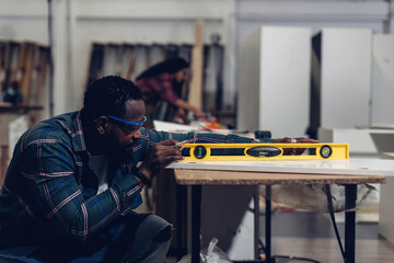 Carpenter working on woodworking machines in carpentry shop. Carpenter working to making wood...