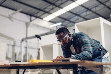 Carpenter working on woodworking machines in carpentry shop. Carpenter working to making wood furniture in wood workshop