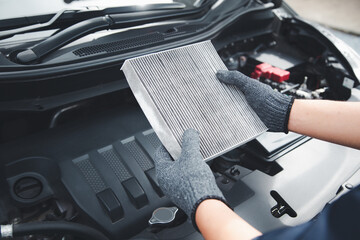 Auto mechanic holding old car air filter pollution to checking cleaning and replacing new for fix...