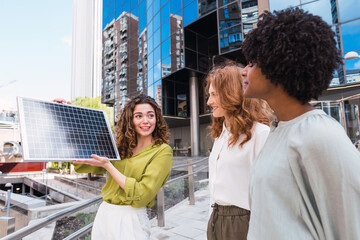 Businesswoman explaining solar panel to colleagues outside the office