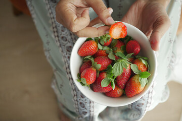 top view of women hand picks Strawberries 