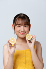 Beauty image of pretty shirtless woman holding two pieces of lemon isolated over white background