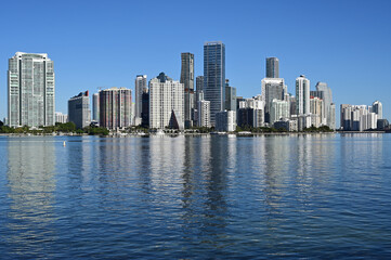 Fototapeta na wymiar City of Miami, Florida skyline reflected in calm water of Biscayne Bay on calm cloudless December morning.