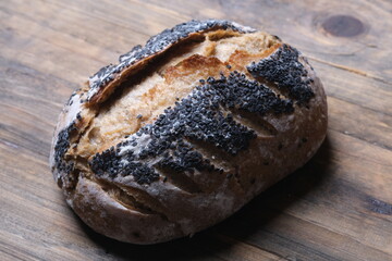 wholewheat rye sourdough bread with black sesame seeds. served on wooden table.