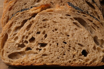 Sourdough bread on the rustic table. Sourdough is a bread made by fermenting dough using wild lactobacillaceae and yeast. Lactic acid from fermentation gives sour taste and improve