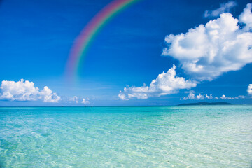 沖縄の美しいサンゴ礁の海にかかる虹