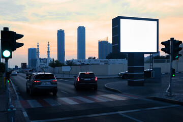 Empty space advertisement board, blank white signboard on roadside in city at sunset.  Blank empty billboard on the city street in United Arab Emirates.