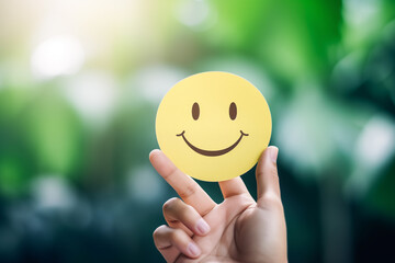 Mental Health Assessment ,Promoting Mental Health Positivity and Satisfaction concept : Hand Holding Paper Cut Smiley Face Reflects Satisfaction and Rating in Wellness Assessment
