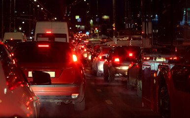 cars with lights on stand in line in front of the barrier  - obrazy, fototapety, plakaty