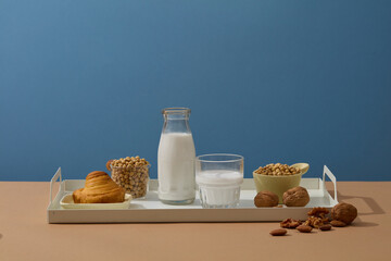 Daily breakfast for healthy lifestyle with a tray featured milk, several types of nuts and a cake. Nuts have been shown to promote weight loss. Branding mockup
