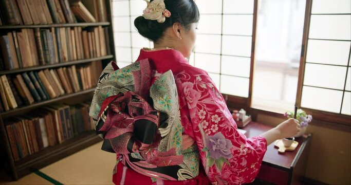 Woman, back and writing with traditional calligraphy, poetry or creativity for art in home library. Girl, person and pen with ink, thinking and idea with vision, paper or haiku for culture in Tokyo