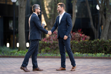 Businessman handshake for teamwork ,successful. Business network concept. Management strategy. Human resources. businessman greeting and making handshake with a businessman outdoors in city walkway.