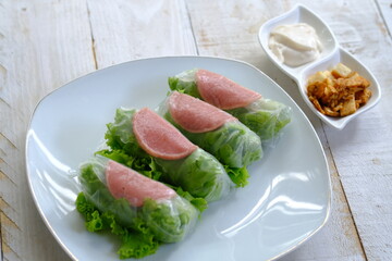 Spring rolls are a rolled appetizer or dim sum commonly found in Chinese and Asian cuisine. Raw fresh vegetable salad roll with mayonnaise.