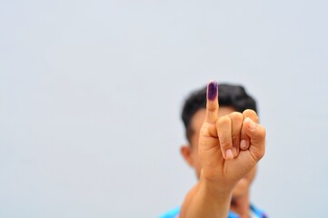 Man showing little finger after voting on Indonesia's presidential election, selective focus
