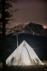 Hot Tent Camping Canadian Rockies Alberta Canada - A white tent with a wood-burning stove inside...