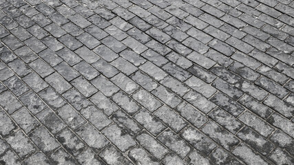 Cobblestone pave top view of old stony sidewalk close up