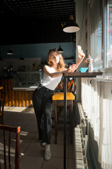 A person sitting on a stool indoors. 4718