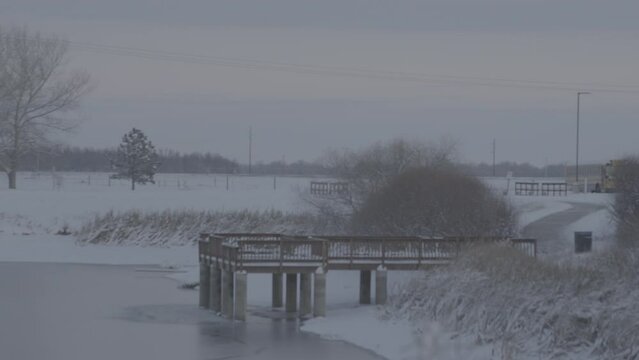 snowy dock in lake during winter