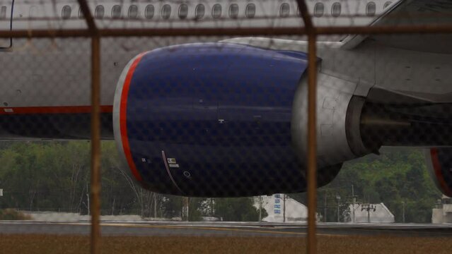 Passenger jet airplane taxiing, close-up. Side view of chassis and engine