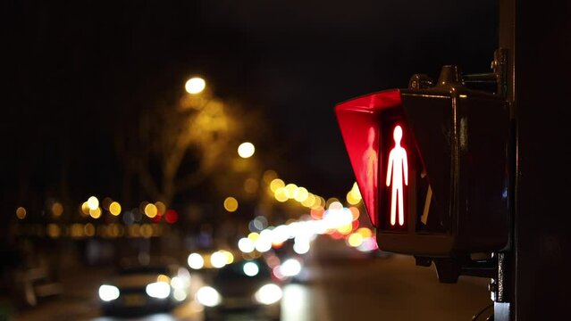 Pedestrian red traffic light in the night. 4K close up selective focus video with a pedestrian traffic red light showing that is not allowed to cross the street. Transportation industry signs.