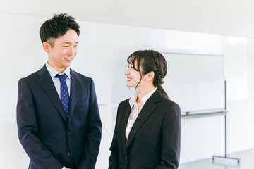 会議室・オフィスにいる若い日本人ビジネスマンとビジネスウーマン
