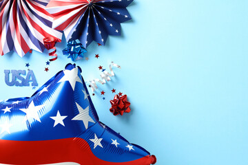 Flat lay composition with American flag balloon, paper fans, confetti stars on blue background. USA...