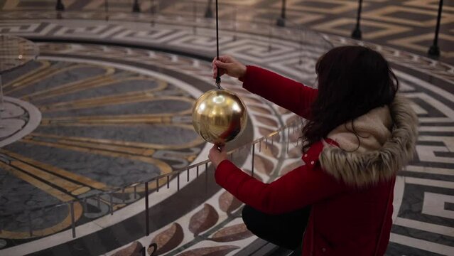 Resetting Foucault Pendulum in Paris Pantheon landmark building. Pendulum showing the Earth moving around its axis.