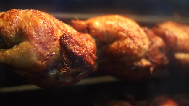 a lot of roast chicken 4k video. Close up view through the window of a chicken grill restaurant. tasty poultry meat video.
