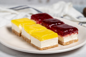 Little cheesecake cakes. Small lemon and raspberry cake on a white background. Close up