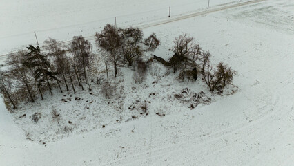 Drone photography of old abandoned wooden house in a rural landscape during winter day