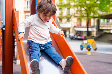 A small girl sliding down a slide