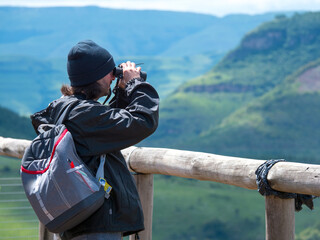 Voyageurs observant à travers ses jumelles, le paysage panoramique de montagnes vertes