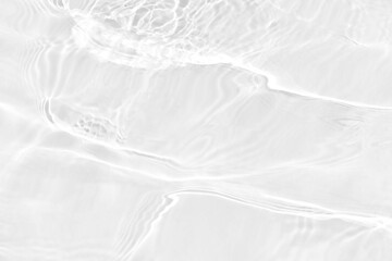 White water with ripples on the surface. Defocus blurred transparent white colored clear calm water surface texture with splashes and bubbles. Water waves with shining pattern texture background.