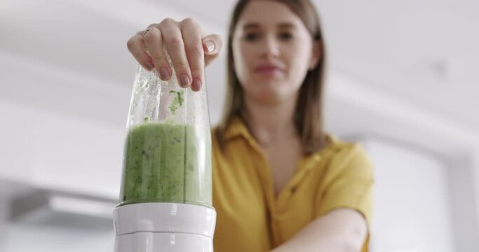 Blender, green juice and woman with diet, detox and healthy food for morning breakfast in kitchen. Nutritionist or person with protein shake, fruits and vegetable smoothie or vegan drink for wellness