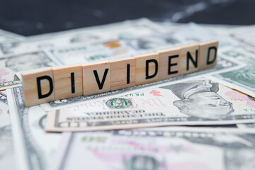 The inscription dividend on the background of American dollars. Investing in Dividend Aristocrats