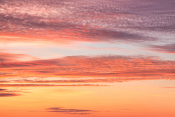 A beautiful sky tinted by the sun leaving vibrant shades of gold, pink, blue and multicolored. Clouds in the twilight evening and morning sky. Cloudy sky background in the evening and during the day.