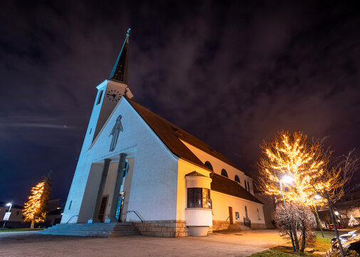 Kirche in Guntramsdorf Niederösterreich mit wunderschön beleuchteten Bäumen zur Weihnachtszeit