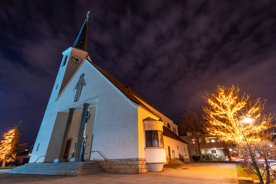 Kirche in Guntramsdorf Niederösterreich mit wunderschön beleuchteten Bäumen zur Weihnachtszeit