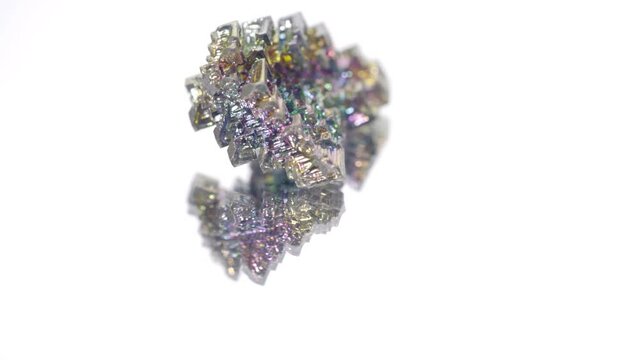 video with small bismuth crystals. multicolor metal rotation isolated on white background