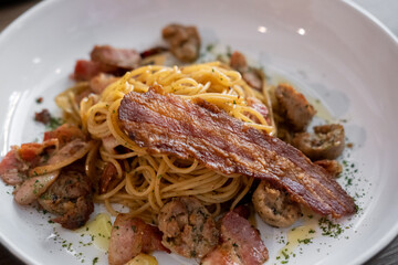Spaghetti Aglio e Olio, garlic and olive oil, served with sausage and bacon