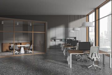 Grey coworking interior with glass meeting area and workspace near window