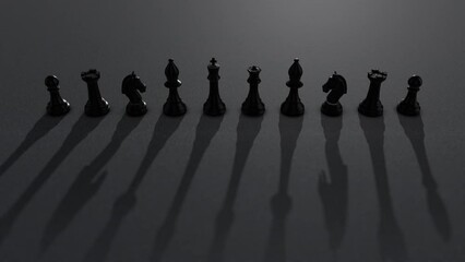 Shot of black chess pieces with dramatic light moving and creating moving dramatic shadows