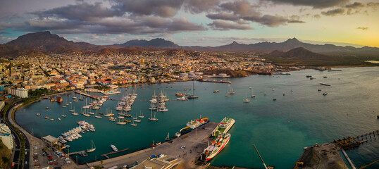 Panoramic aerial view of Mindelo city at sunset, with the marina and boats in the foreground,...