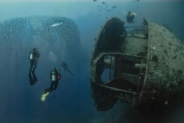 Divers swim alongside the legendary SS Thistlegorm, a World War II shipwreck in the Red Sea,...