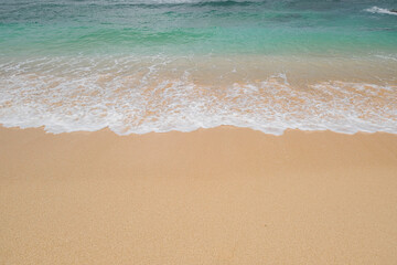Blue ocean waves on sandy beach